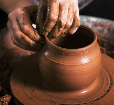 manos dando molde a una vasija de barro